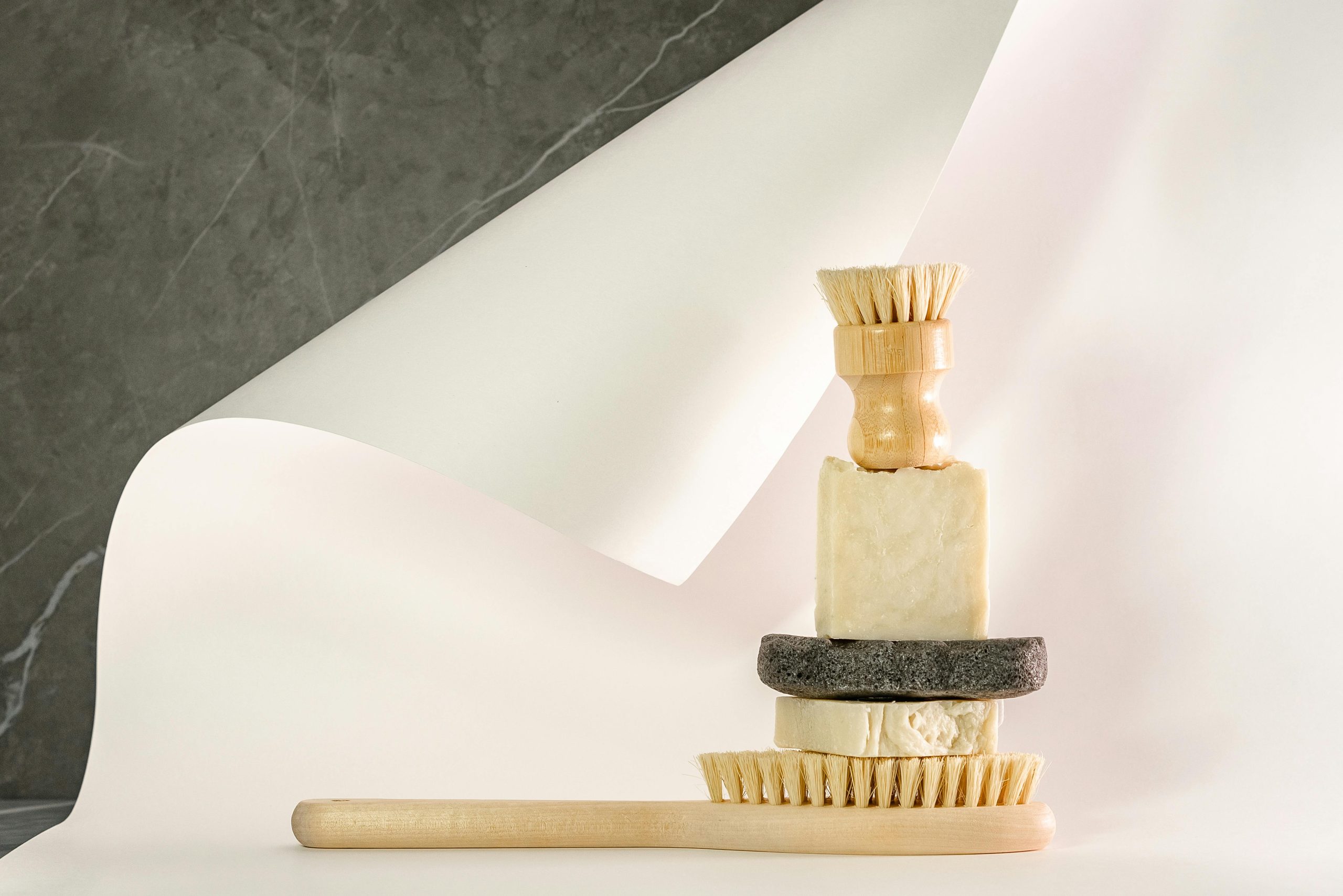 Artistic still life of eco-friendly cleaning tools and soaps in neutral tones.